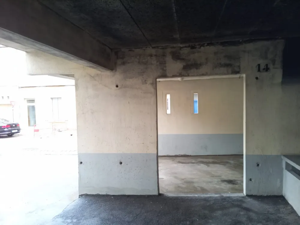 Plafond et murs d'un parking couvert noircis par la fumée, avant intervention